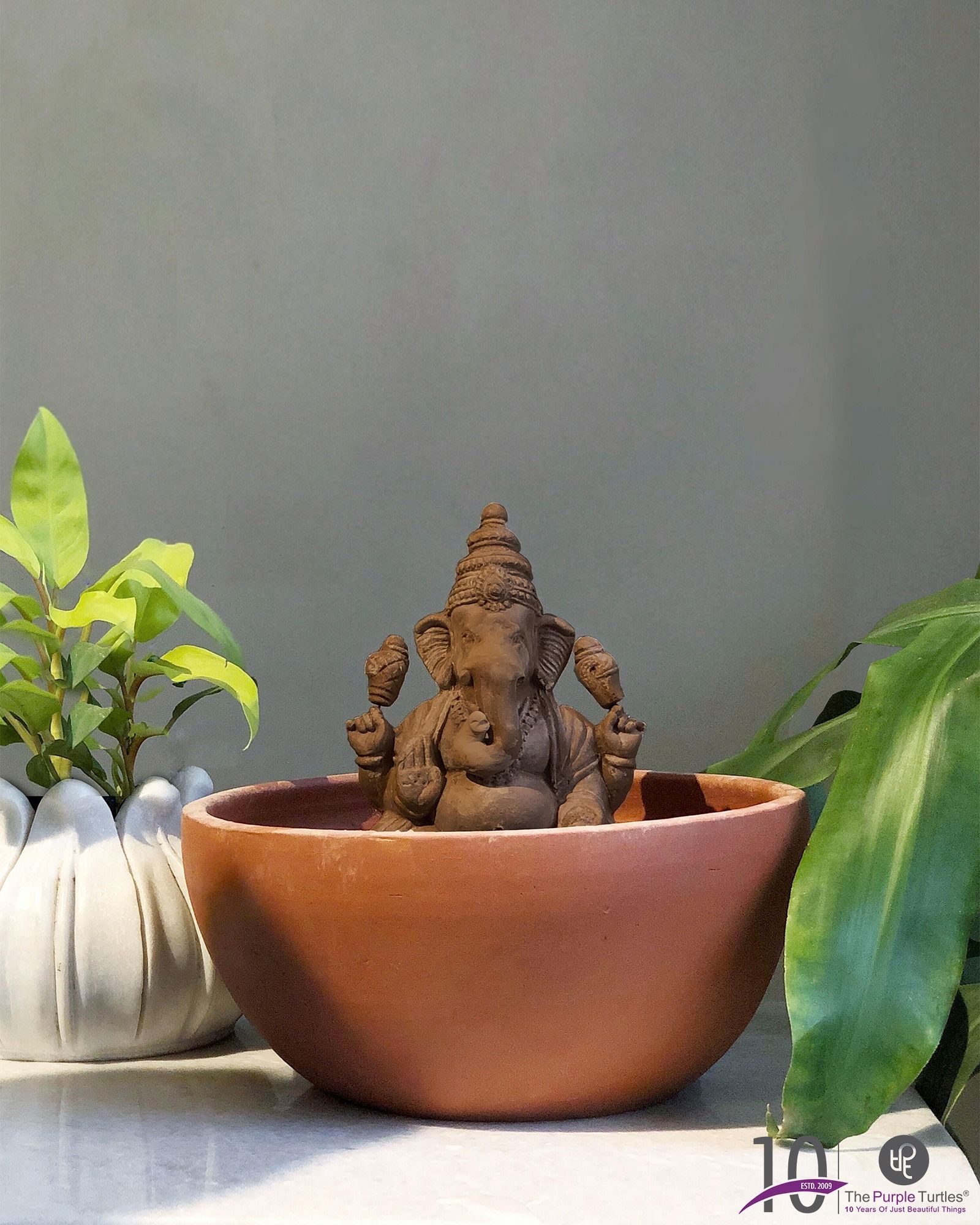 Ganesh Chaturthi Carousel: Eco-friendly terracotta Ganesha idol styled with a candle and flowers, slide 2