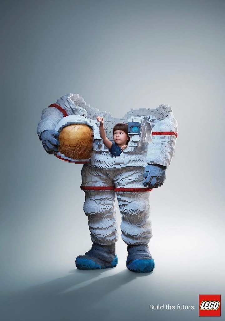 Toy Stores creative ad: Young child standing inside a life-size brick-built astronaut suit