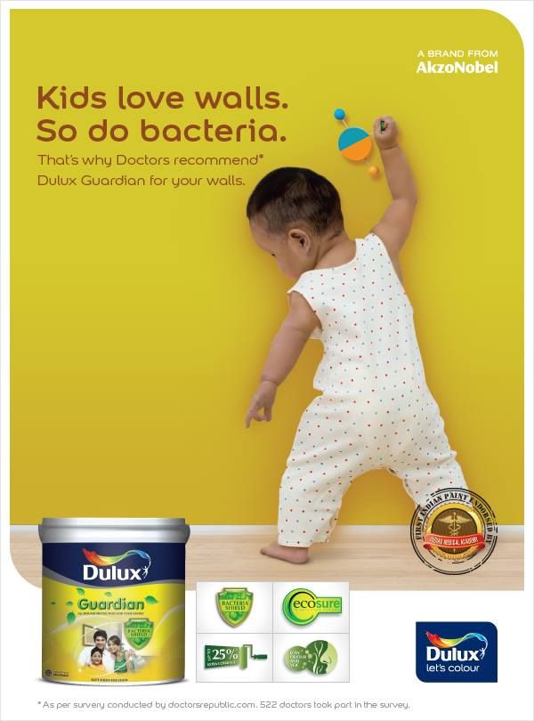 Poster: Toddler in polka-dot romper scribbling on a yellow wall