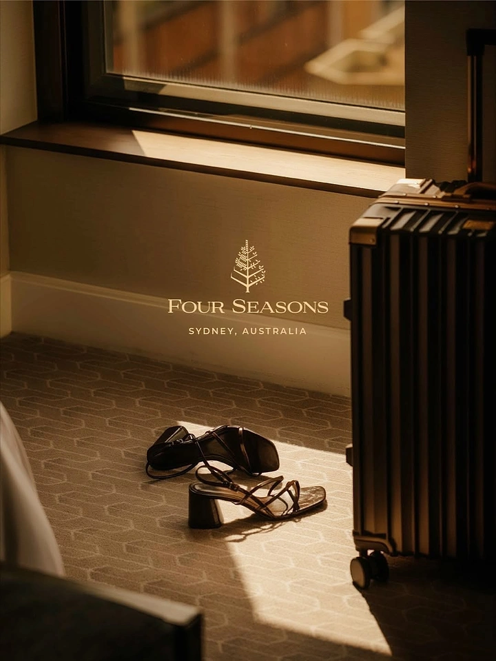 Creative ad: Discarded sandals beside a suitcase in a sunlit hotel room