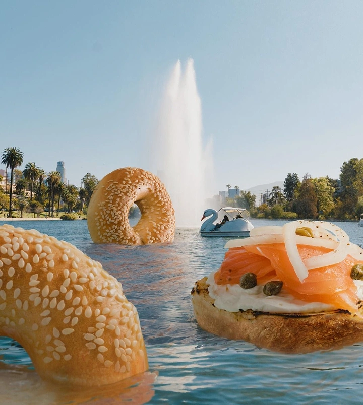 Cloud Kitchens & Food Trucks creative ad: Giant bagels floating in city lake