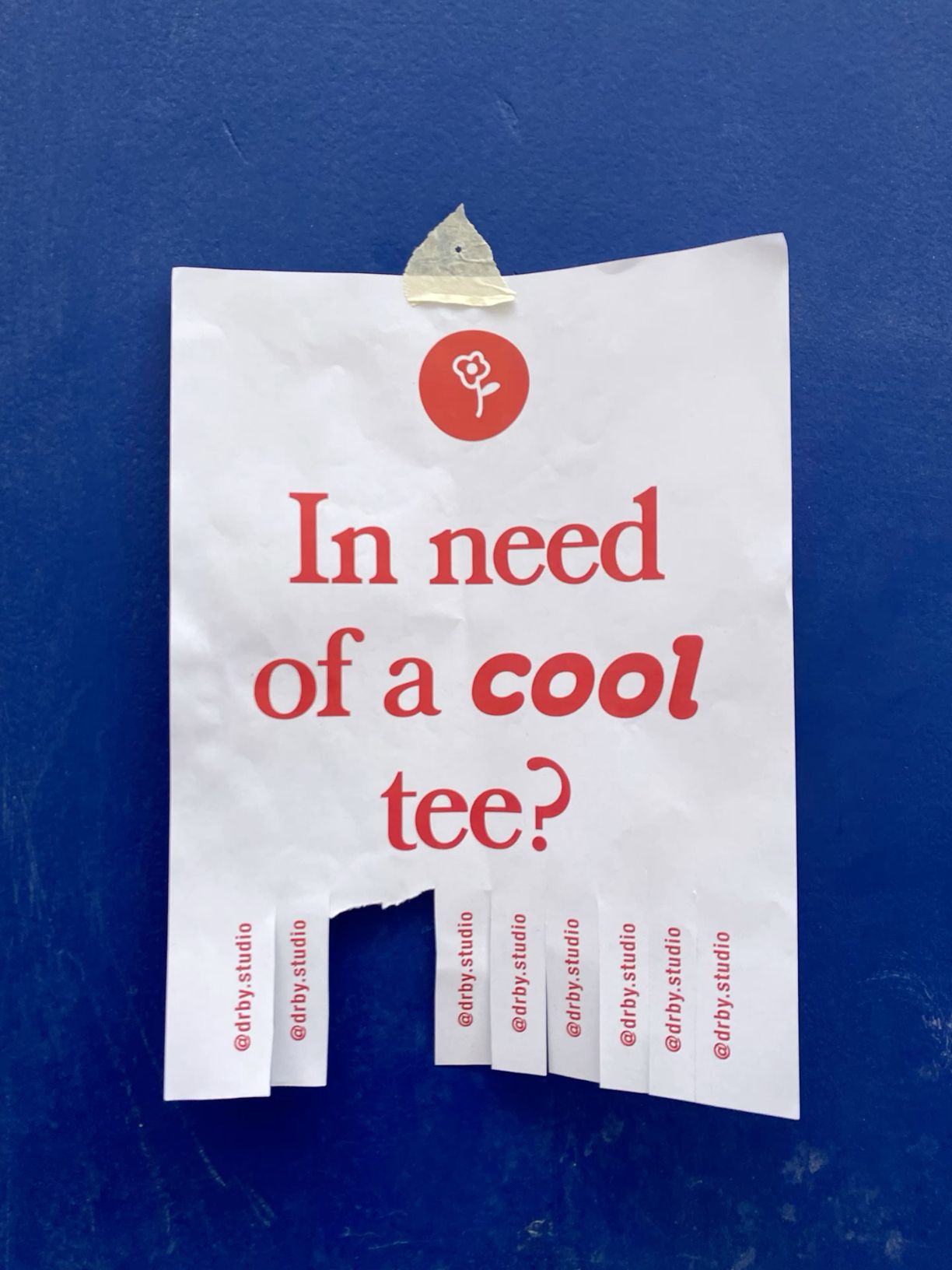 Poster: Tear-off paper flyer taped to a deep blue wall