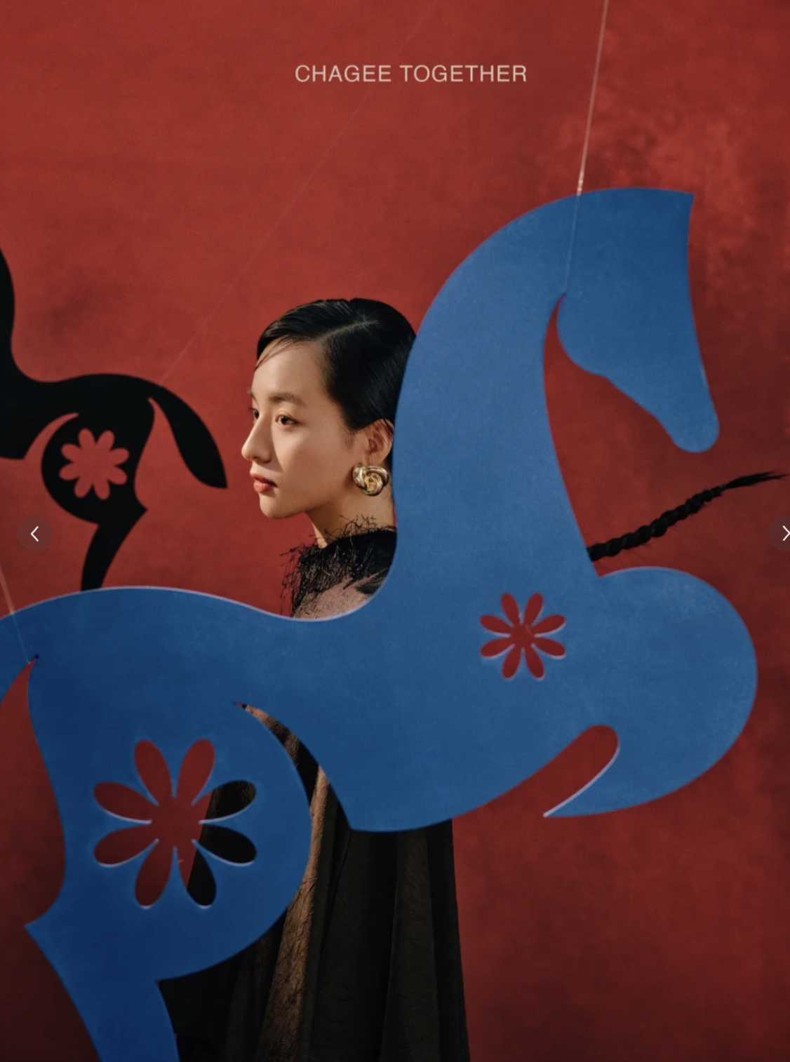 Woman in profile framed by hanging blue horse cutout