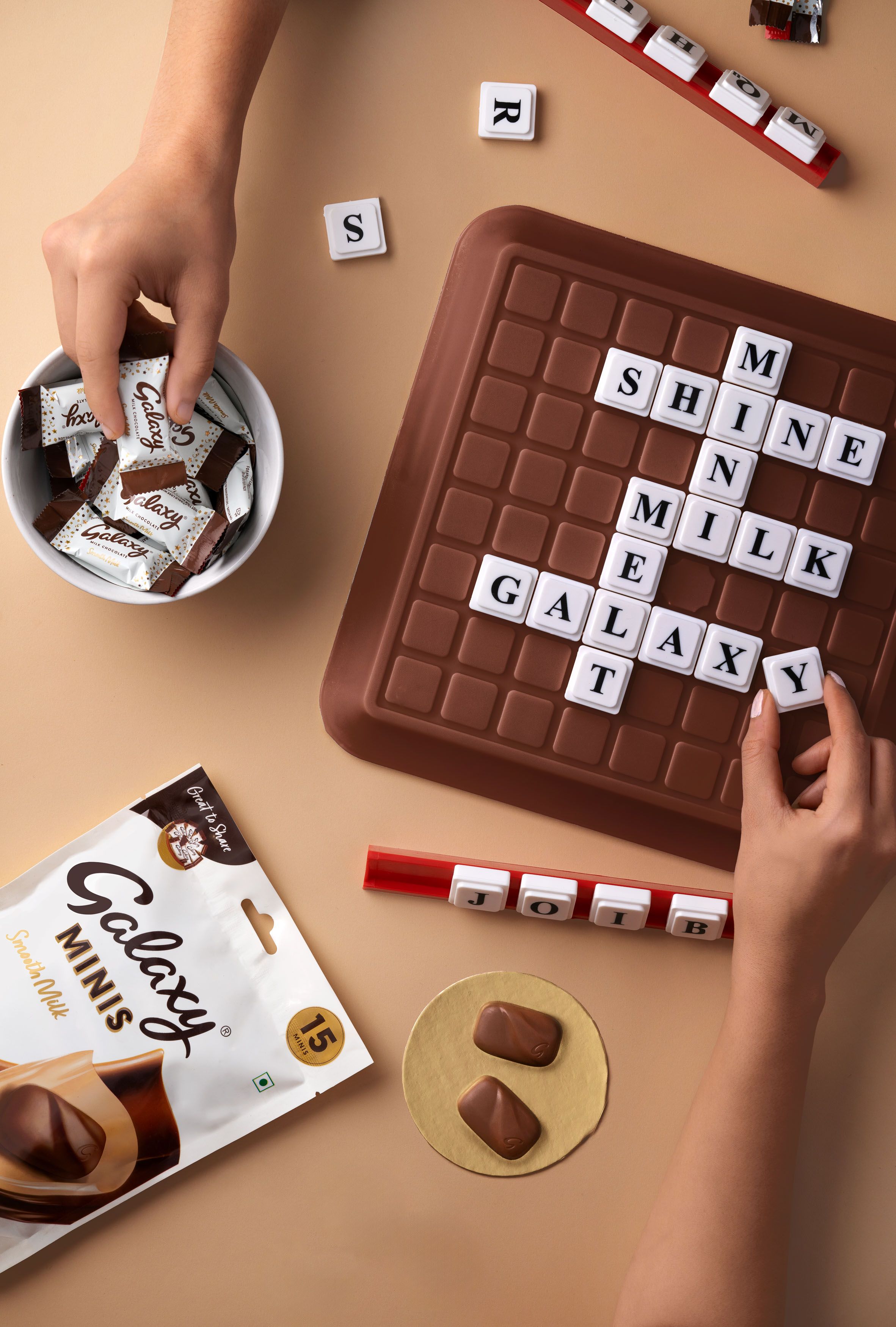 Instagram post: Chocolate-bar Scrabble board spelling brand words, flat lay