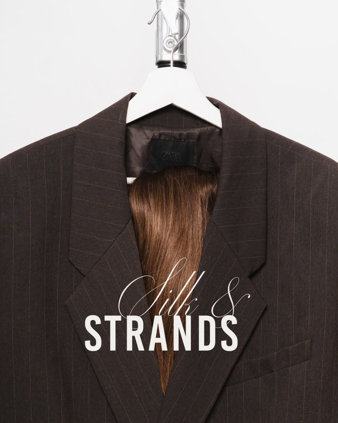 Carousel: Brown pinstripe blazer on hanger with a hair extension draped inside like a lining, slide 1