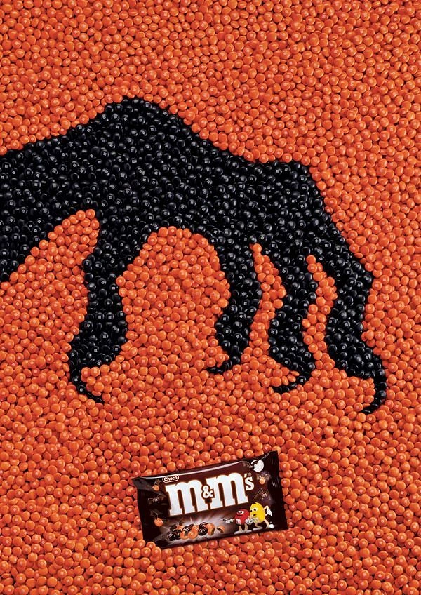 Halloween creative ad: Monster claw made of candies forming an 'm'