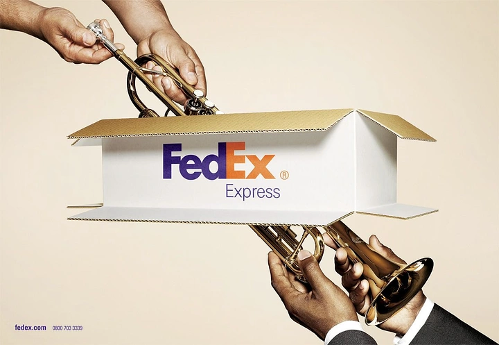 Logistics creative ad: Trumpet passing through an open-ended branded shipping box between two pairs of hands