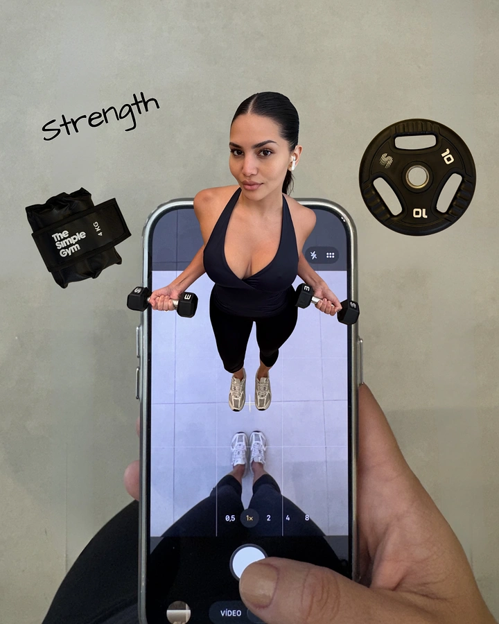 Sports Goods Stores creative ad: Hand holding a phone, with a woman lifting dumbbells popping out of the screen