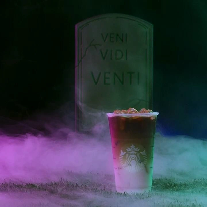 Halloween creative ad: Iced drink in clear cup before a tombstone in fog