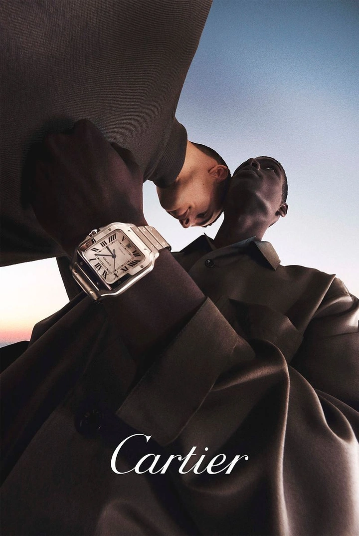 Creative ad: Close-up of a steel square watch on a wrist, with two men seen from below