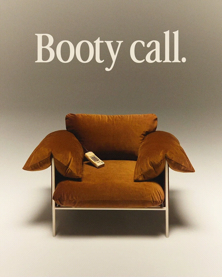 Creative ad: Rust velvet lounge armchair with a vintage phone on the seat