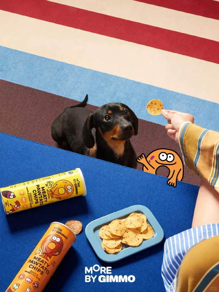 Creative ad: Dachshund eyeing a chip held out by a hand, next to product canisters