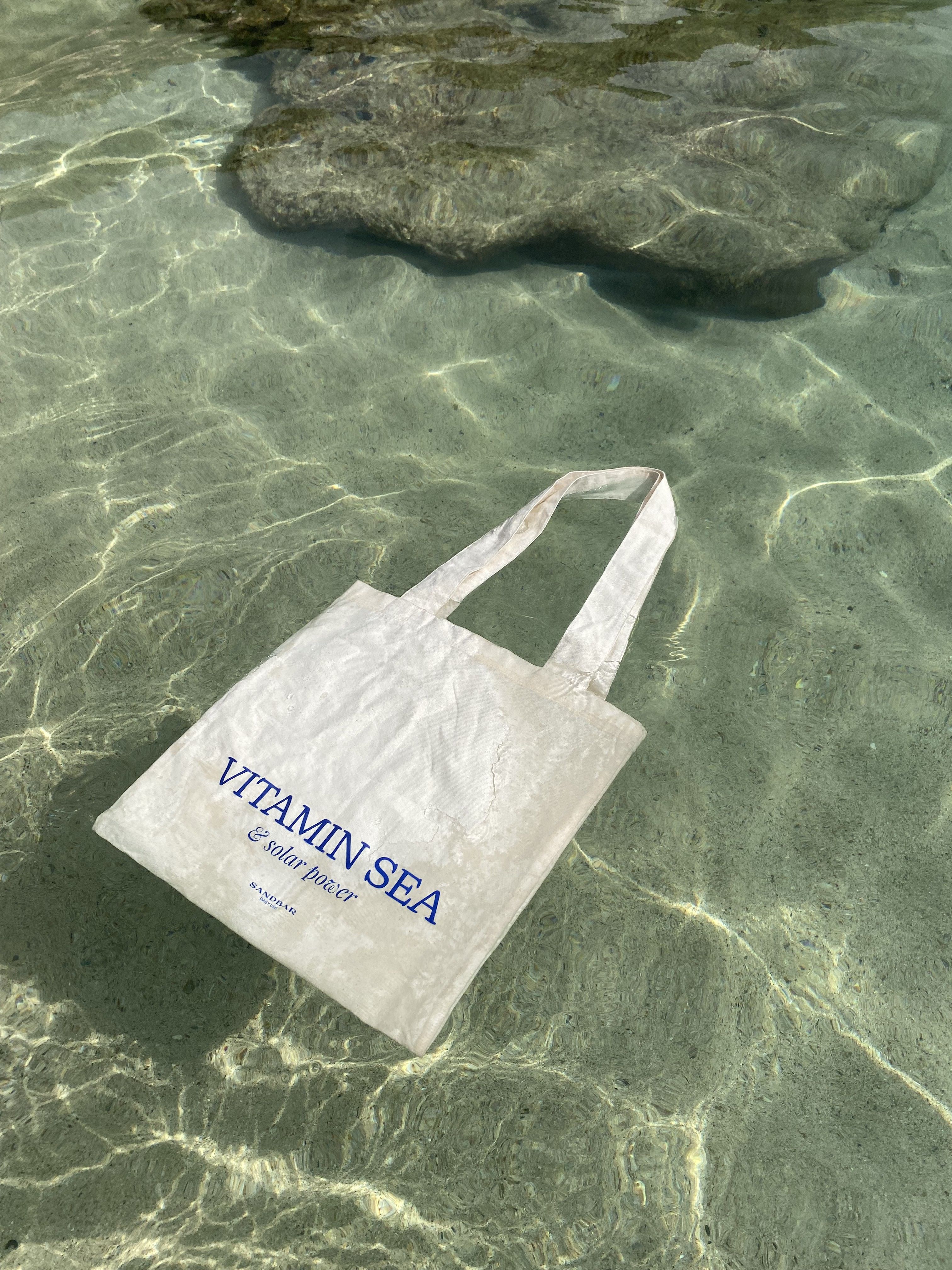 Instagram post: Vitamin Sea pun with tote in water, slide 1