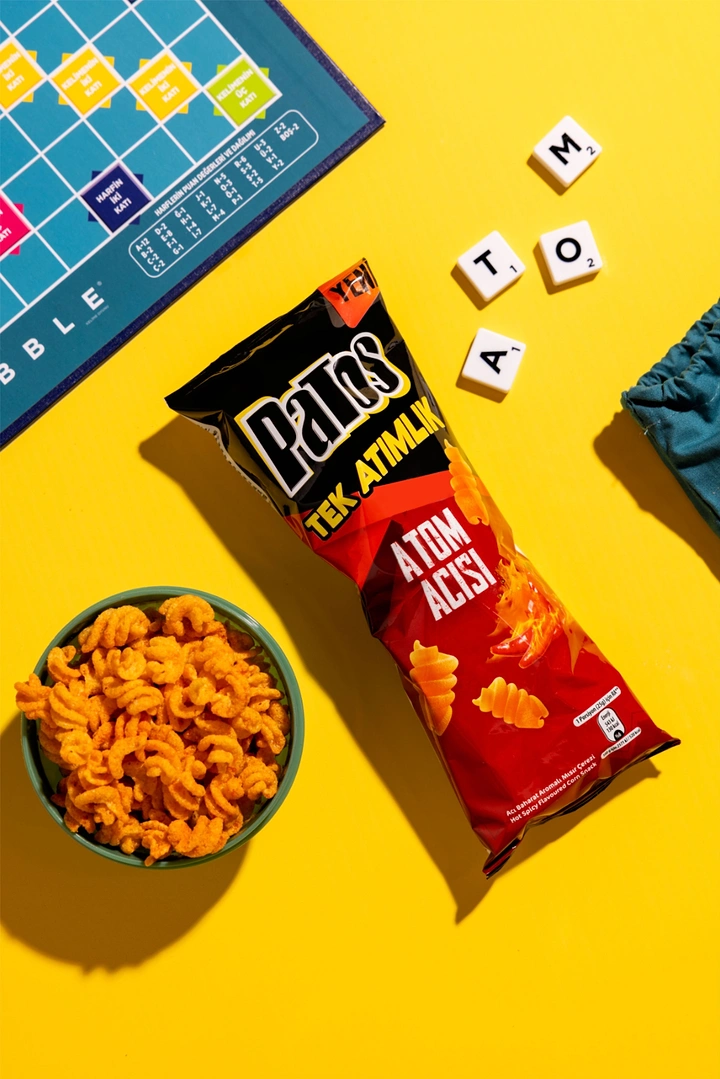 Snacks & Namkeen Brands creative ad: Scrabble tiles spell product name ATOM