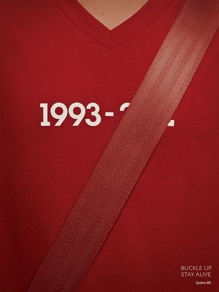 Nonprofit & Social Cause creative ad: Seatbelt across a red V-neck t-shirt, covering the end of a printed date range