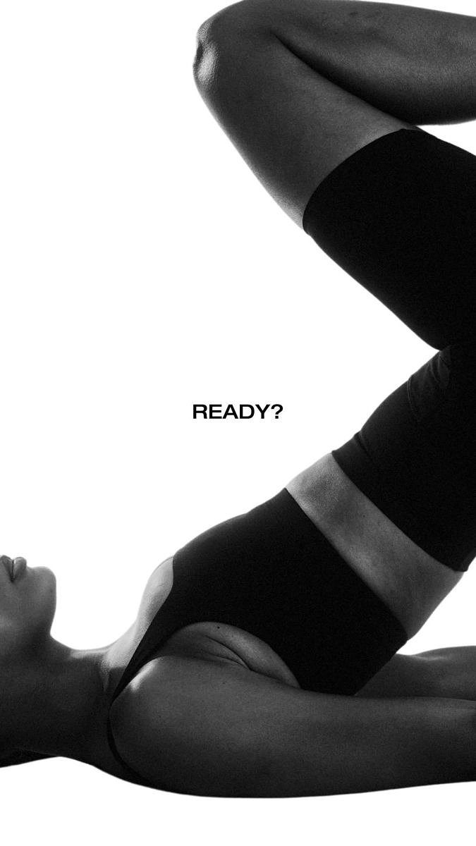 Yoga Studios creative ad: Black-and-white cropped woman in black activewear doing a leg raise