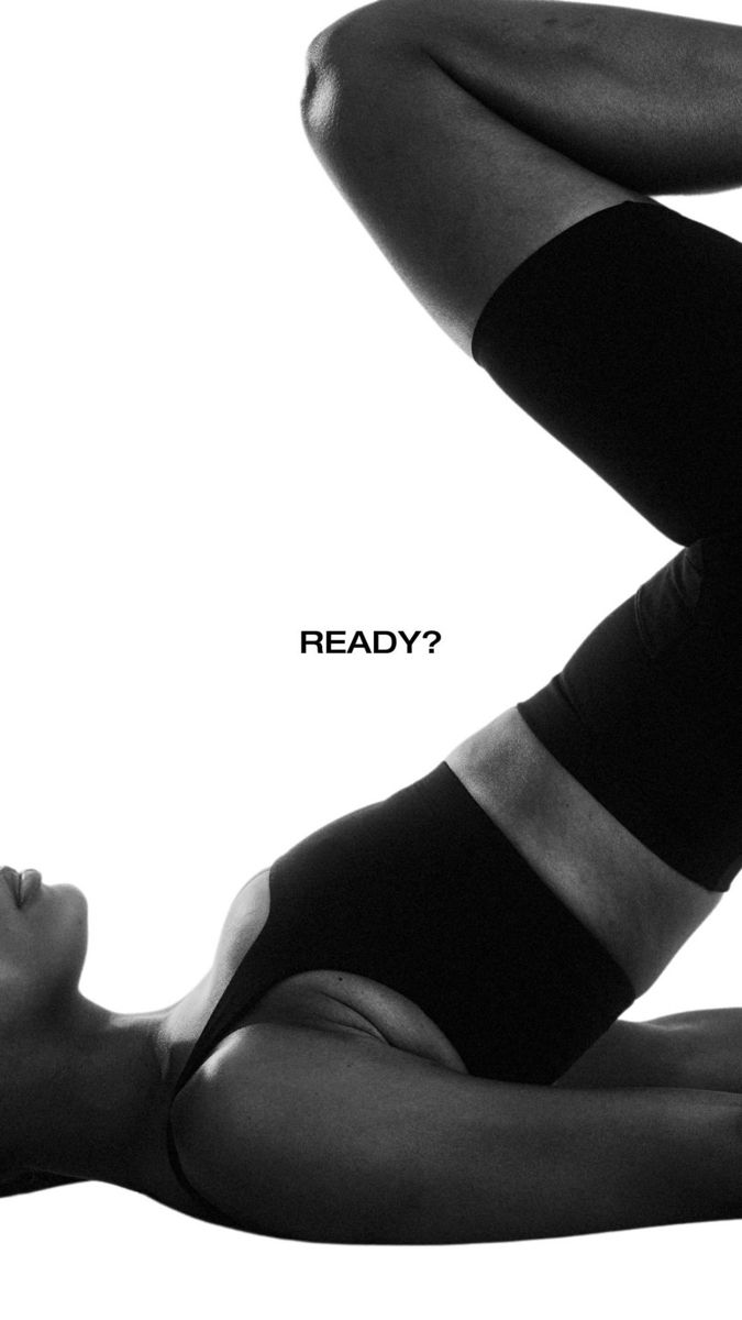 Story: Black-and-white cropped woman in black activewear doing a leg raise