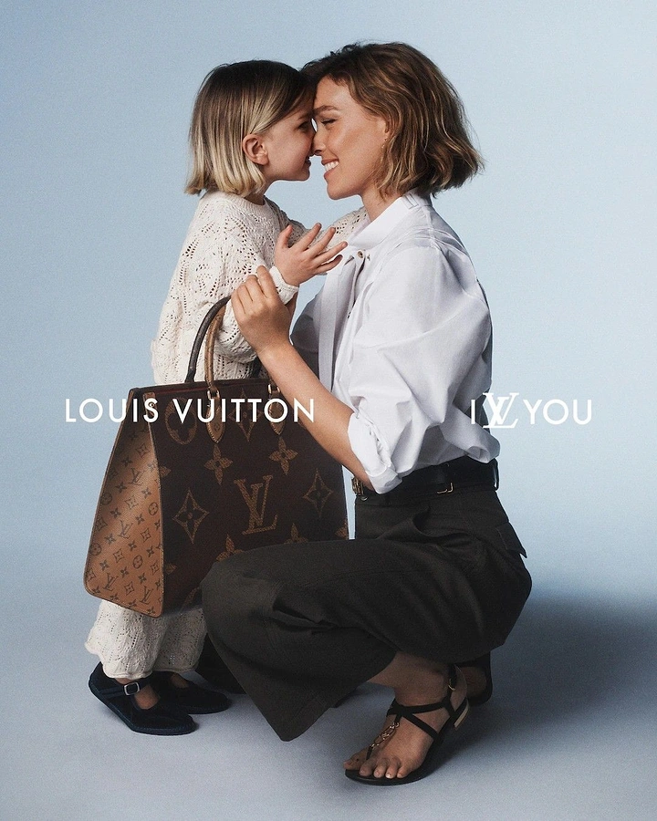 Mother's Day creative ad: Mother crouching nose-to-nose with her daughter, holding a monogram tote