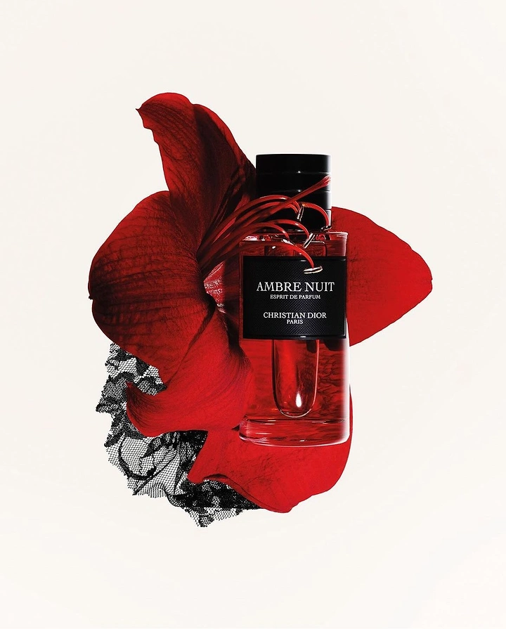 Creative ad: Red perfume bottle over a crimson amaryllis bloom and black lace