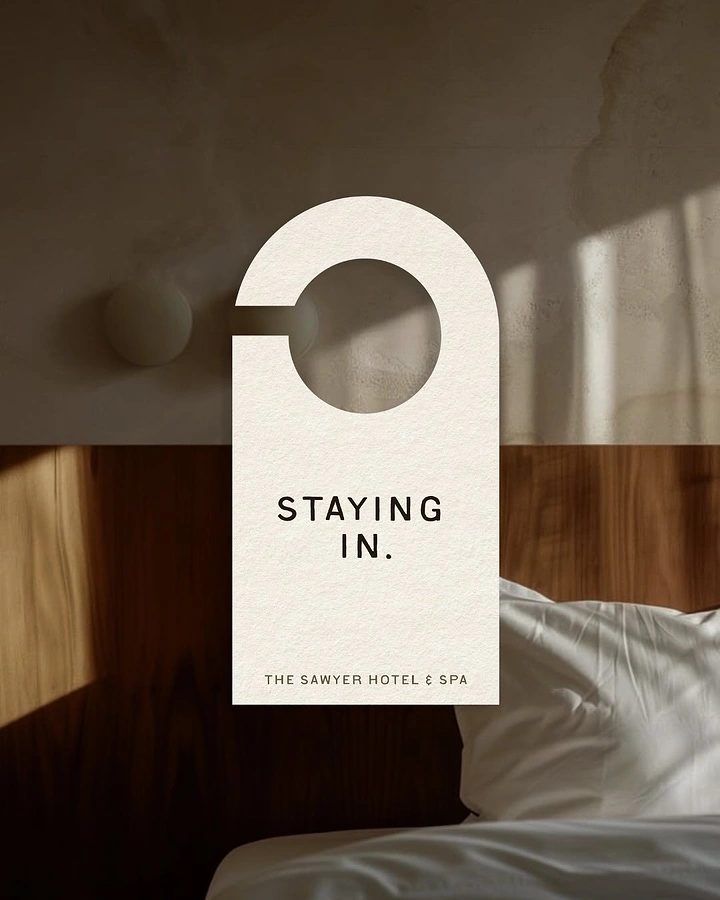 Spa & Massage creative ad: Cream door-hanger card over sunlit hotel bed