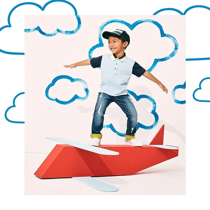 Kids Clothing creative ad: Paper plane ride with doodle clouds