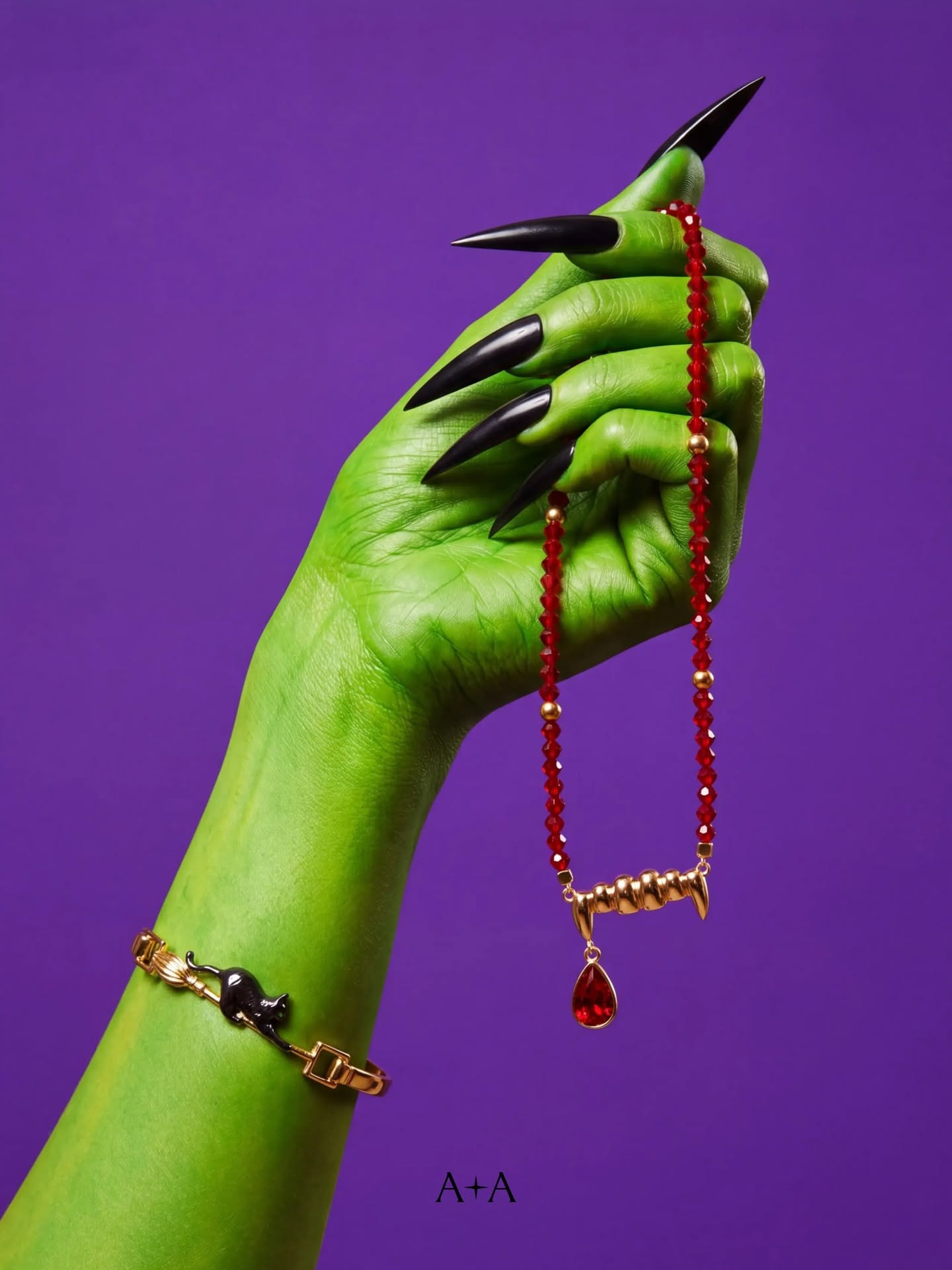 Green witch hand holding a vampire-fang pendant necklace