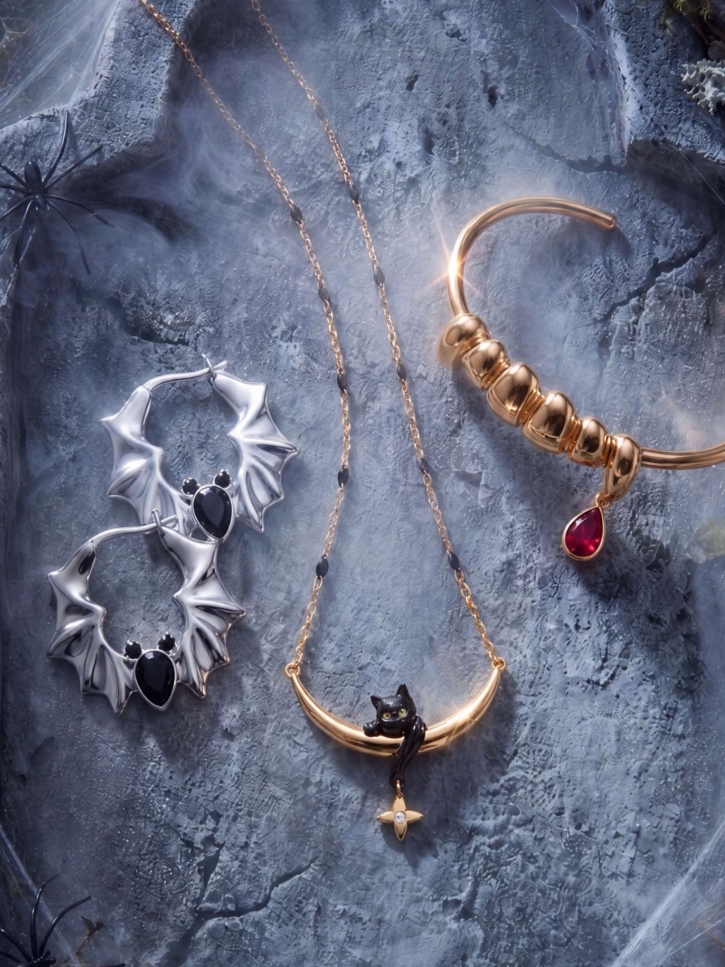 Green witch hand holding a vampire-fang pendant necklace