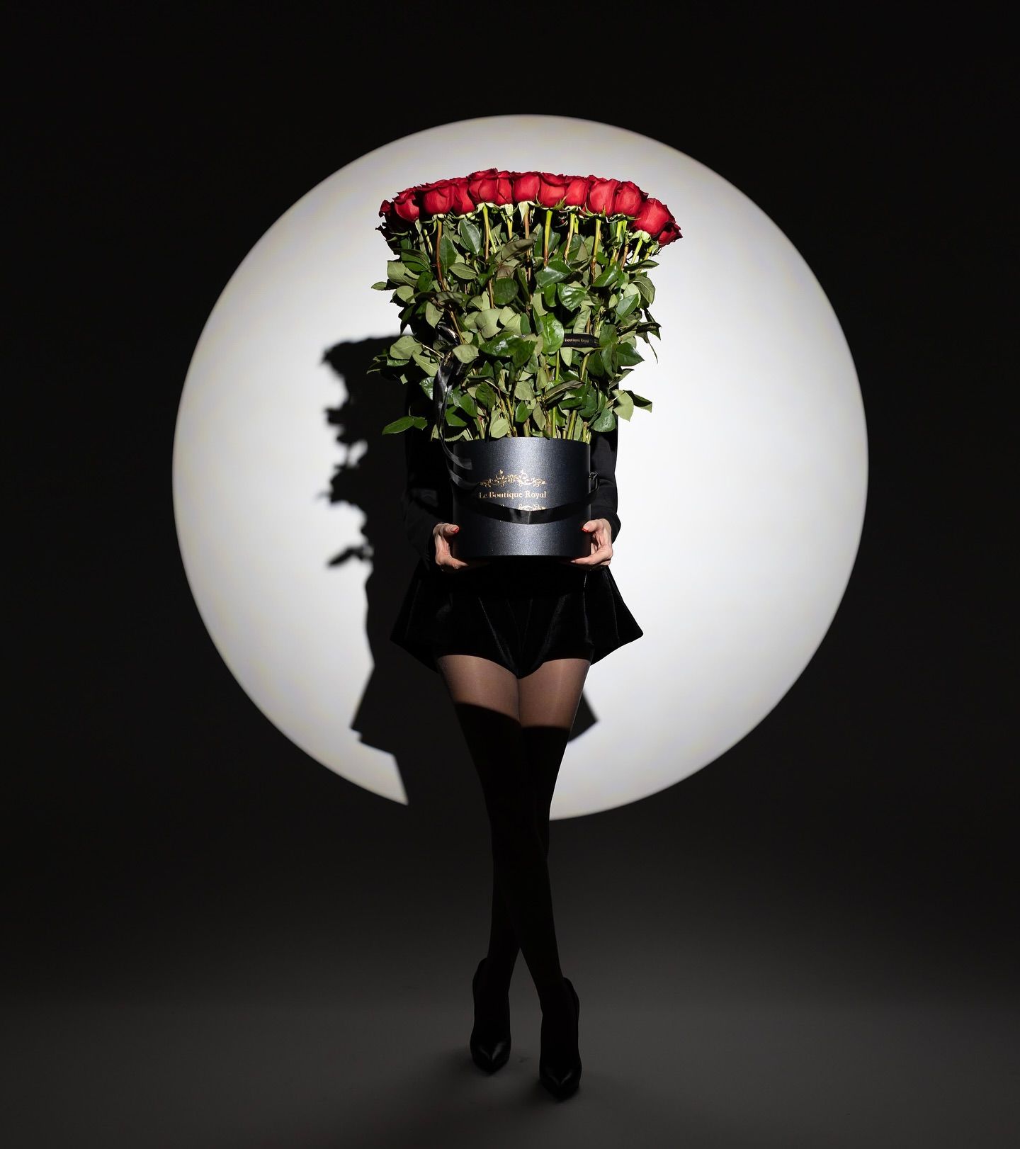 Poster: Person concealed behind a cylindrical box of red roses