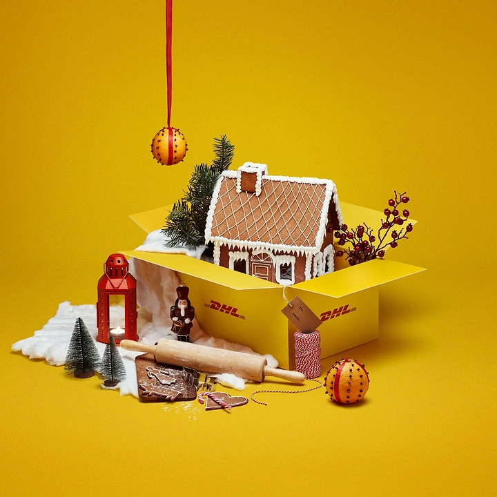 Christmas creative ad: Gingerbread house in an open branded shipping box