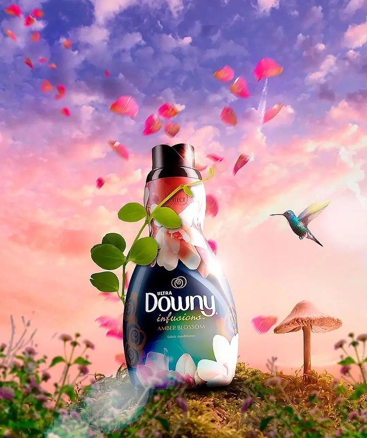 Detergents & Home Cleaning Products creative ad: Fabric conditioner bottle in a surreal sunset meadow with floating petals