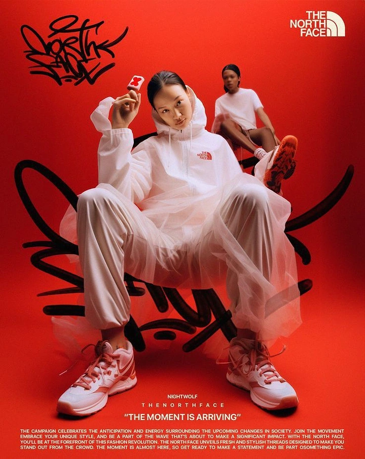 Creative ad: Model in white tulle-layered tracksuit seated on a black graffiti-scribble chair, second model behind