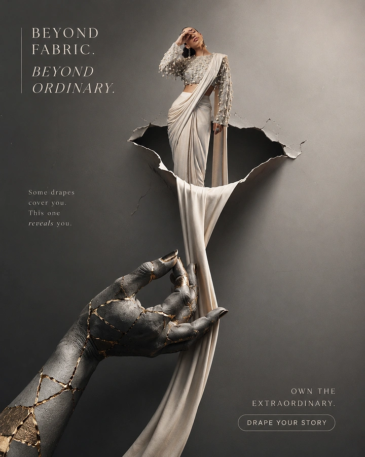 Fashion creative ad: Model in drape saree emerging from torn wall, fabric pulled by gold-cracked stone hand