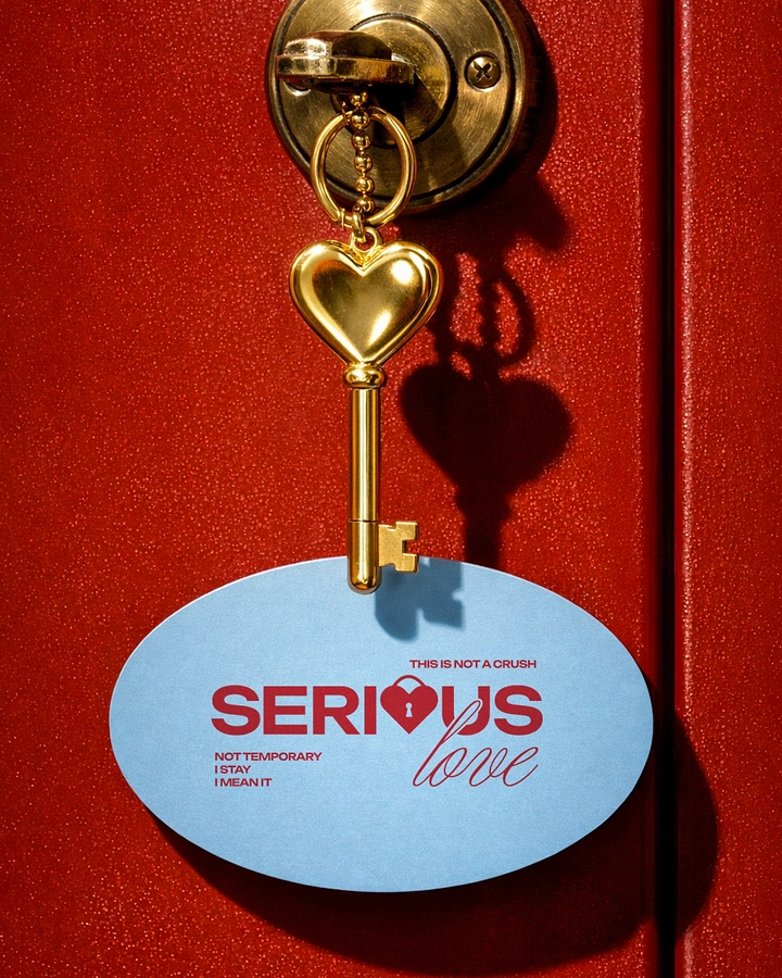 Valentine's Day creative ad: Gold heart-shaped key in a red door lock with a hanging blue oval tag