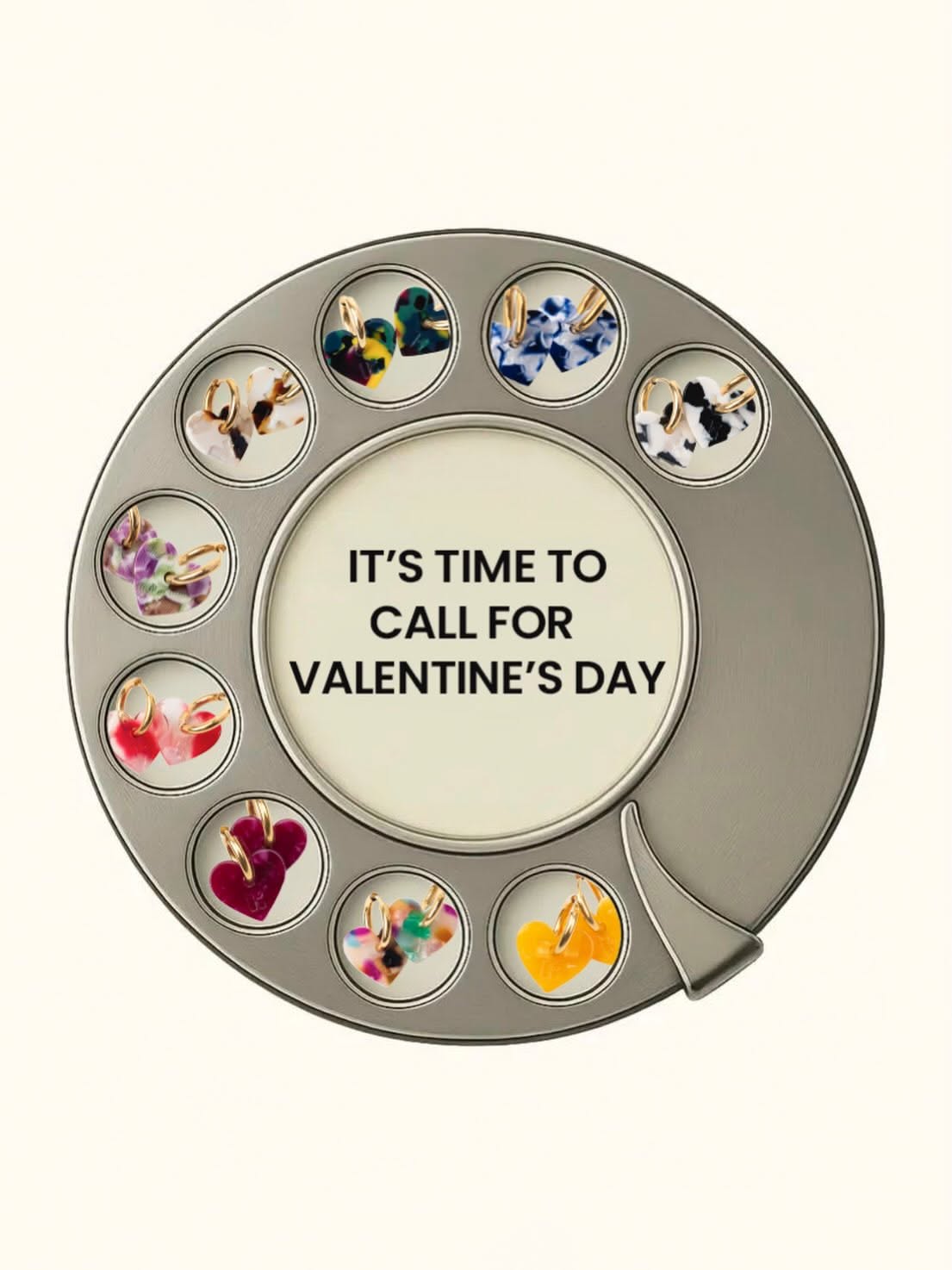 Rotary phone dial with heart earrings in its finger holes