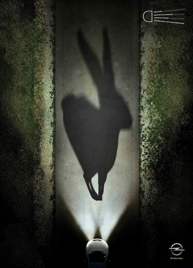 Automotive creative ad: Tiny hare casting a giant shadow in car headlights