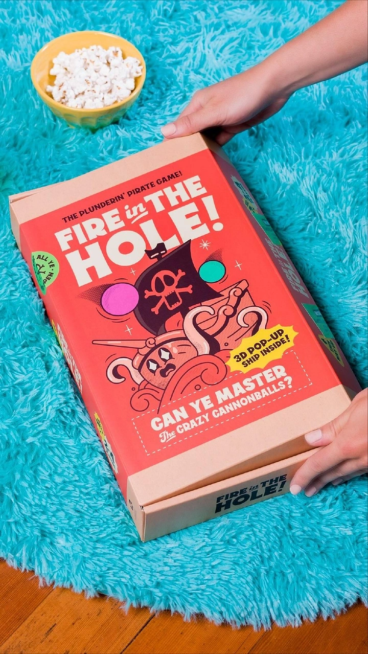 Board Games & Game Cafes creative ad: Game packaging staged in playful pool setting