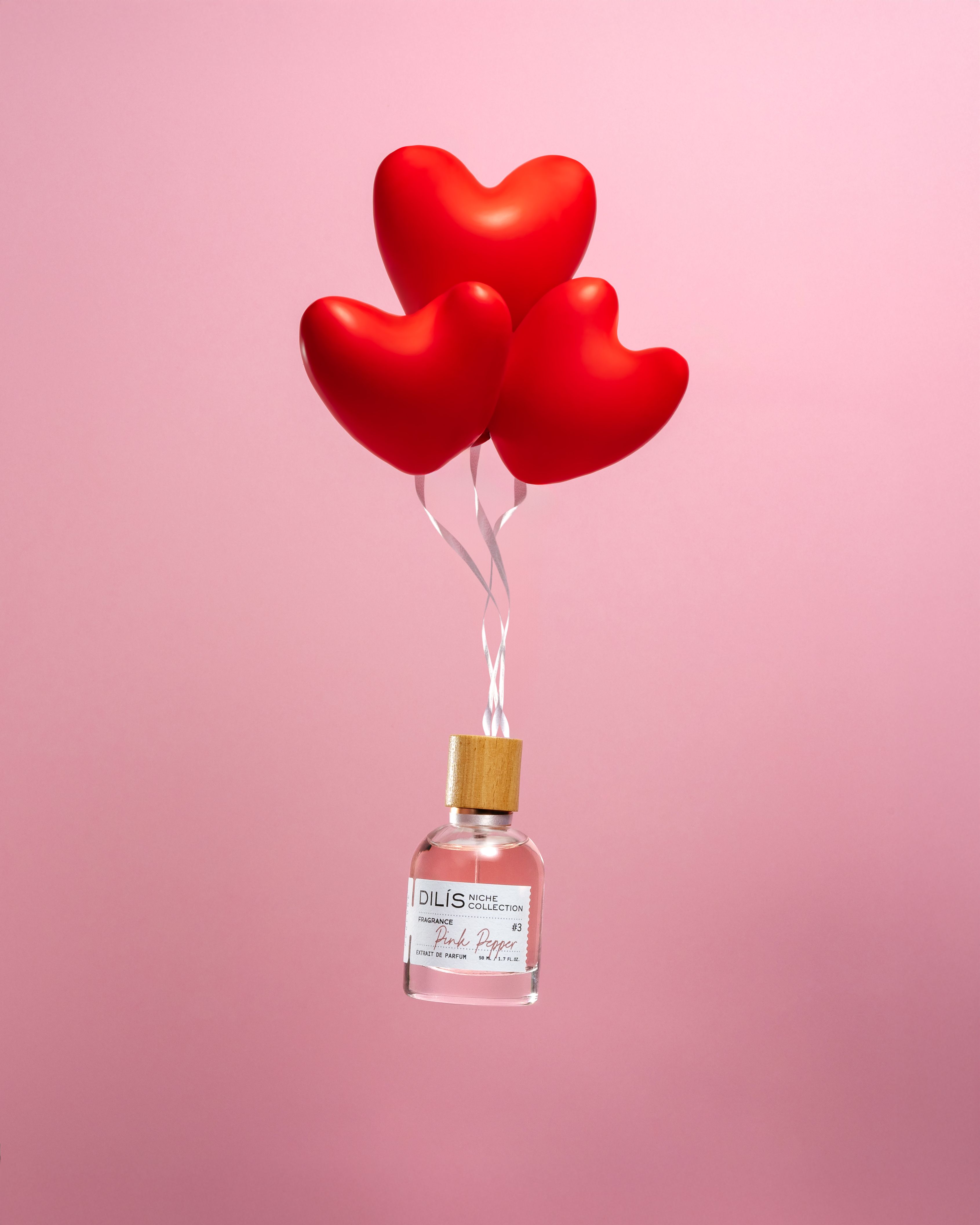 Valentine's Day Instagram post: Perfume bottle lifted by three red heart balloons