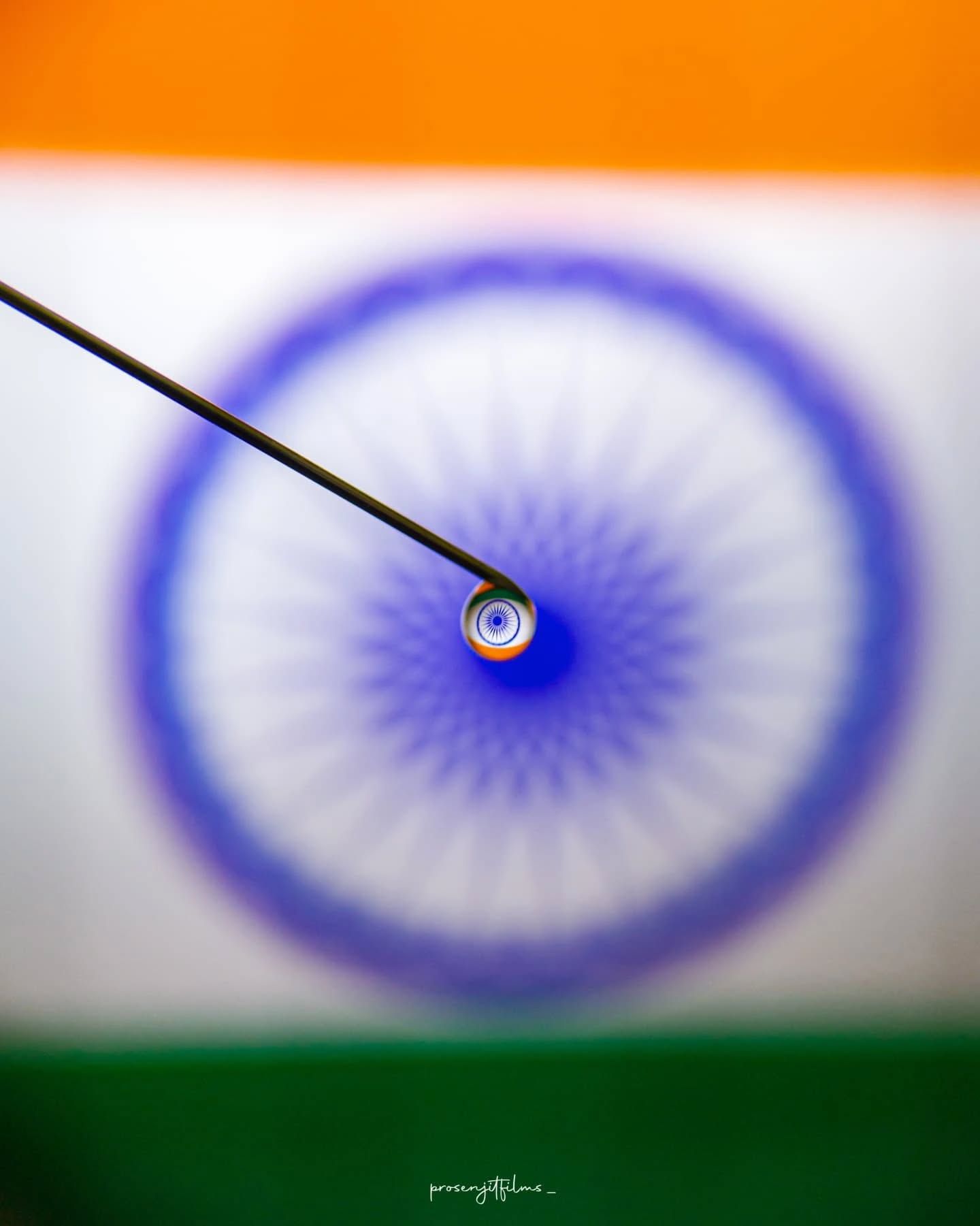 Macro shot of a needle threaded with saffron, white and green threads