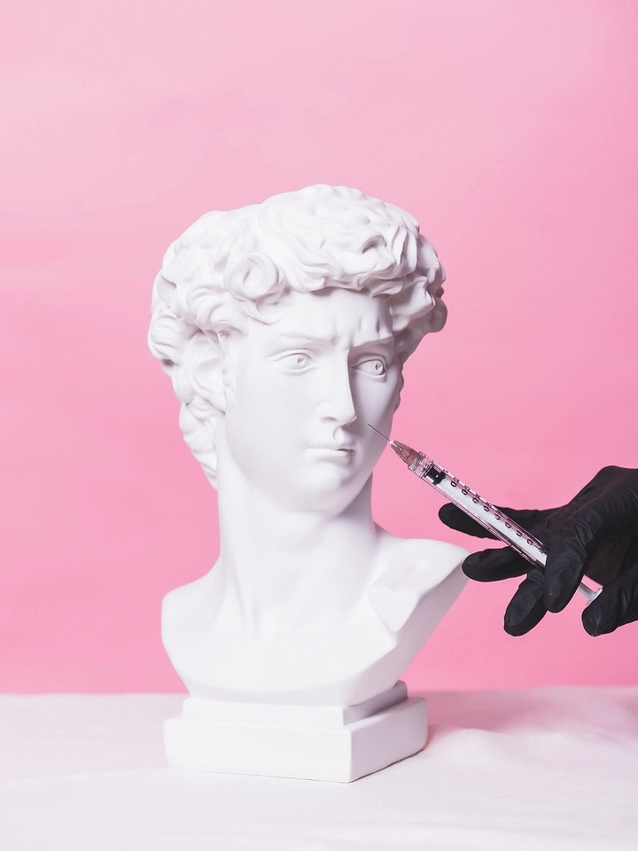 Plastic Surgery Clinics creative ad: Classical bust turned into injection metaphor
