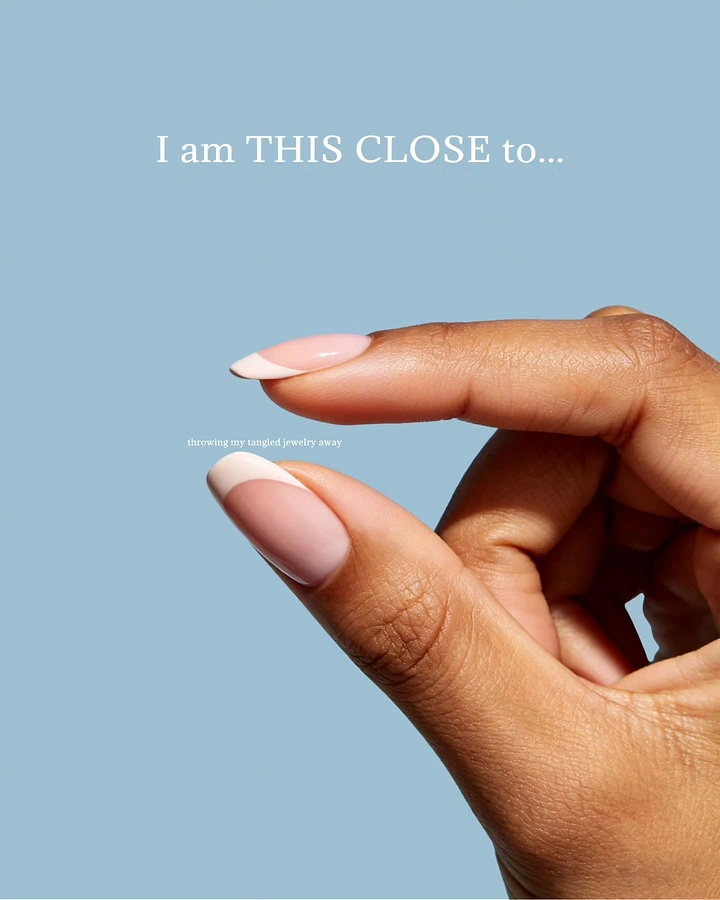 Nail Salons creative ad: Hand with French-tip nails making a 'this close' pinch gesture