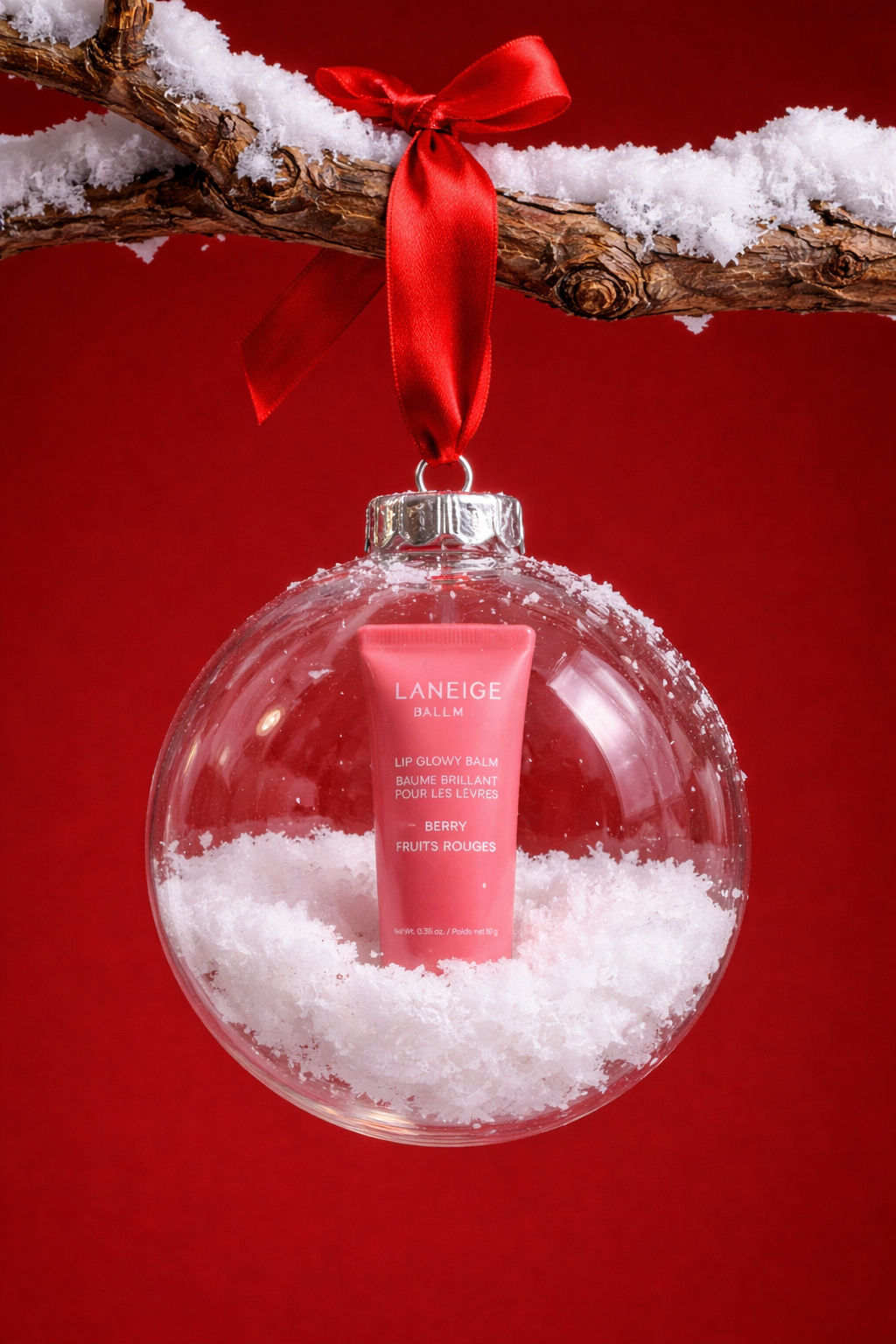 Christmas Instagram post: Lip balm tube inside a clear snow-filled bauble
