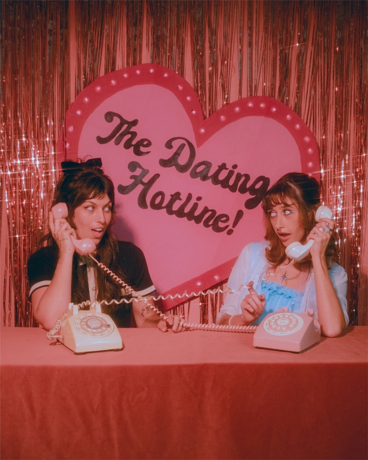 Valentine's Day creative ad: Two women on retro rotary phones in front of a heart sign