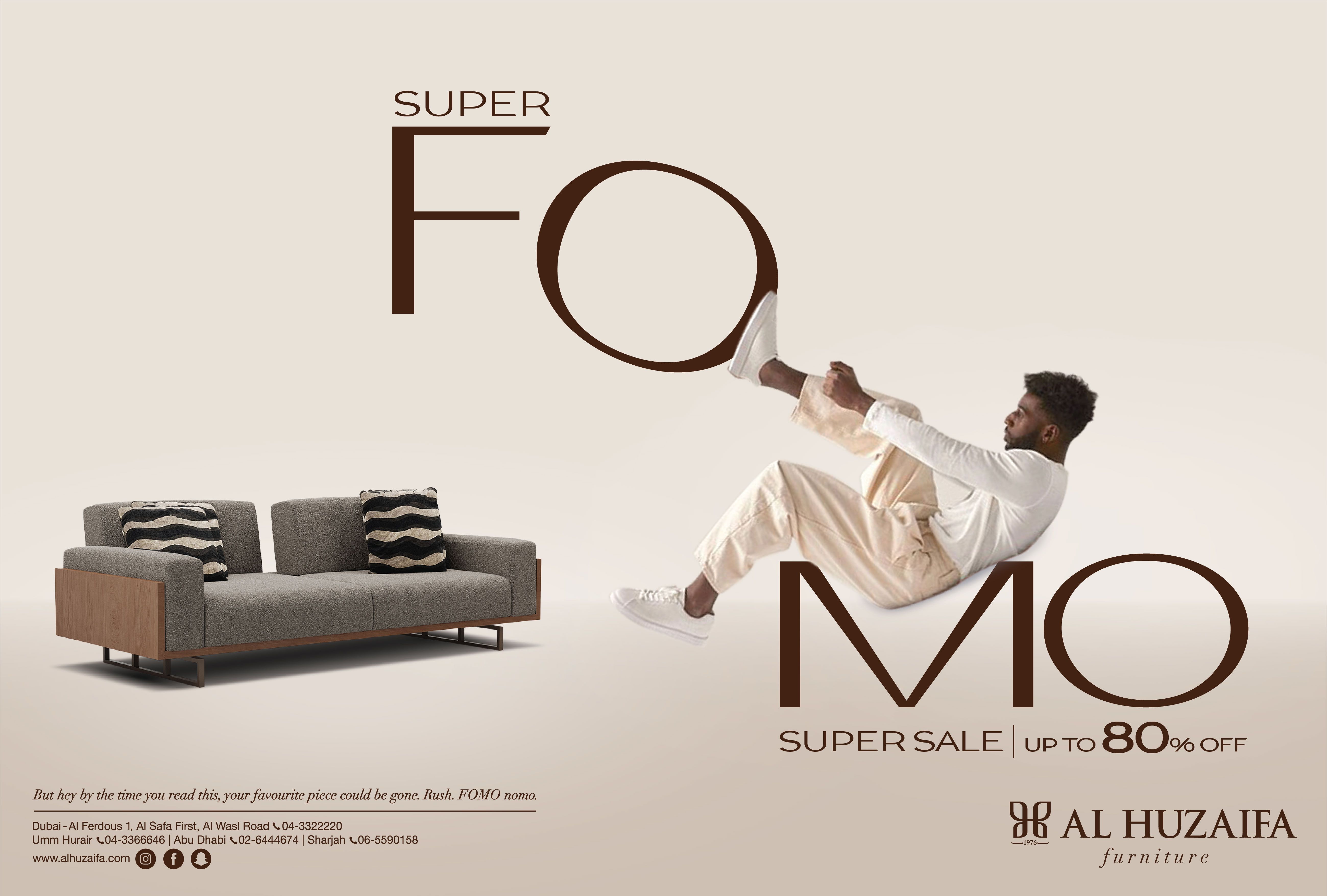 Poster: Man leaning back into giant letters beside a sofa