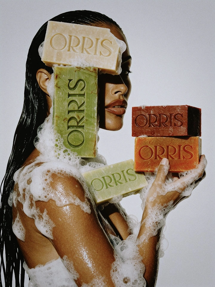 Beauty & Salon creative ad: Woman in profile covered in lather, holding stacked colourful soap bars