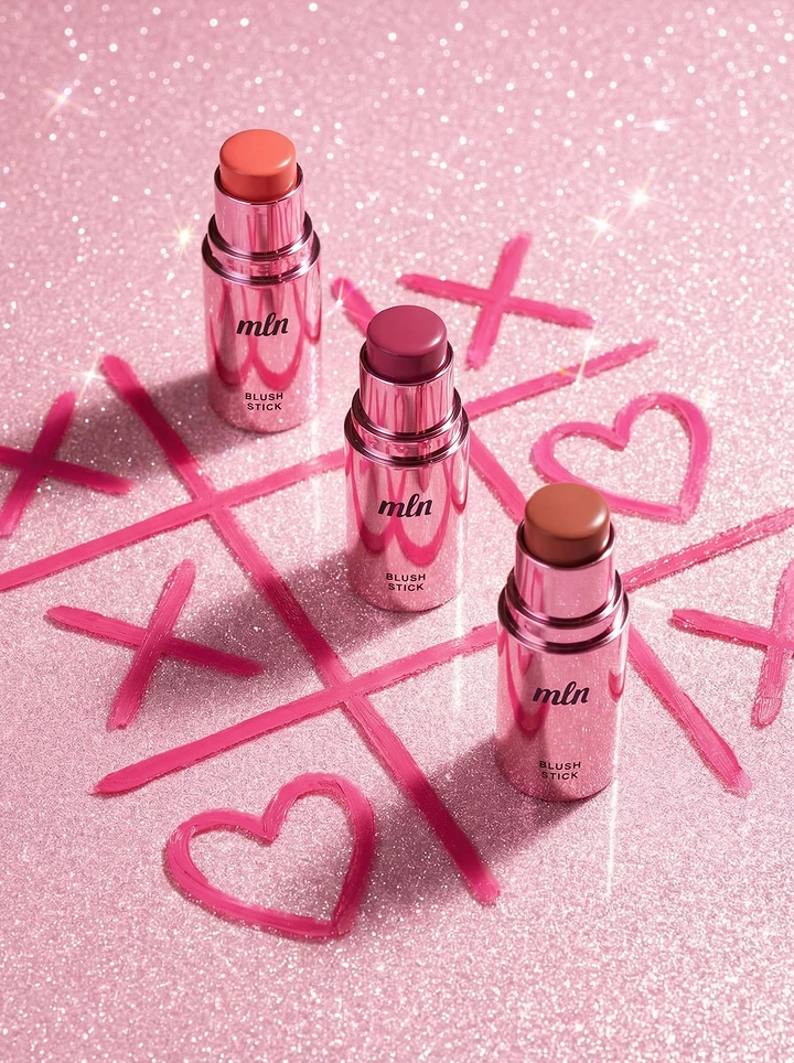 Valentine's Day creative ad: Three pink-chrome blush sticks on a glitter tic-tac-toe board