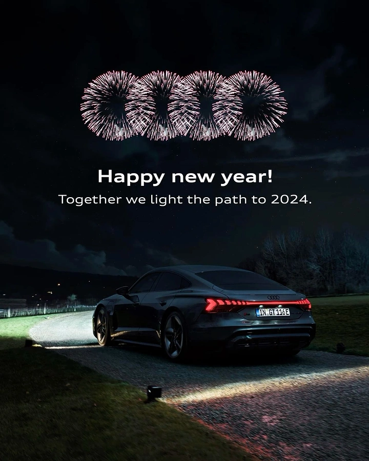 New Year creative ad: Fireworks bursting in the shape of four interlocking rings above a dark sedan on a night driveway