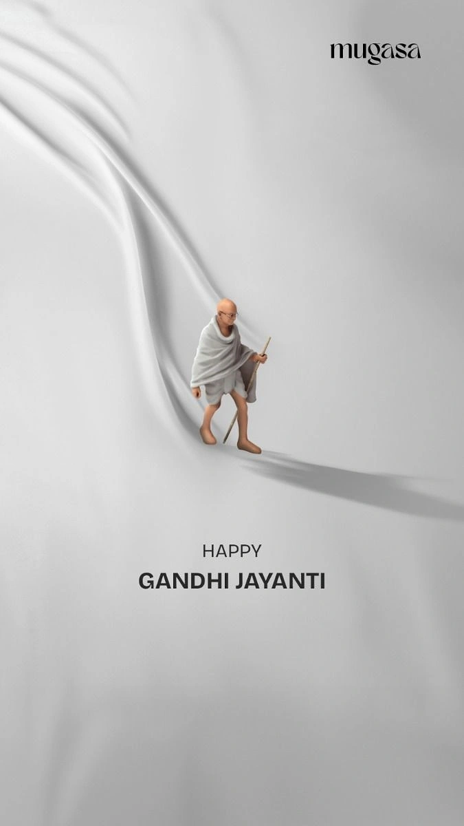 Gandhi Jayanti creative ad: Miniature 3D Gandhi figure walking along a fold of white fabric