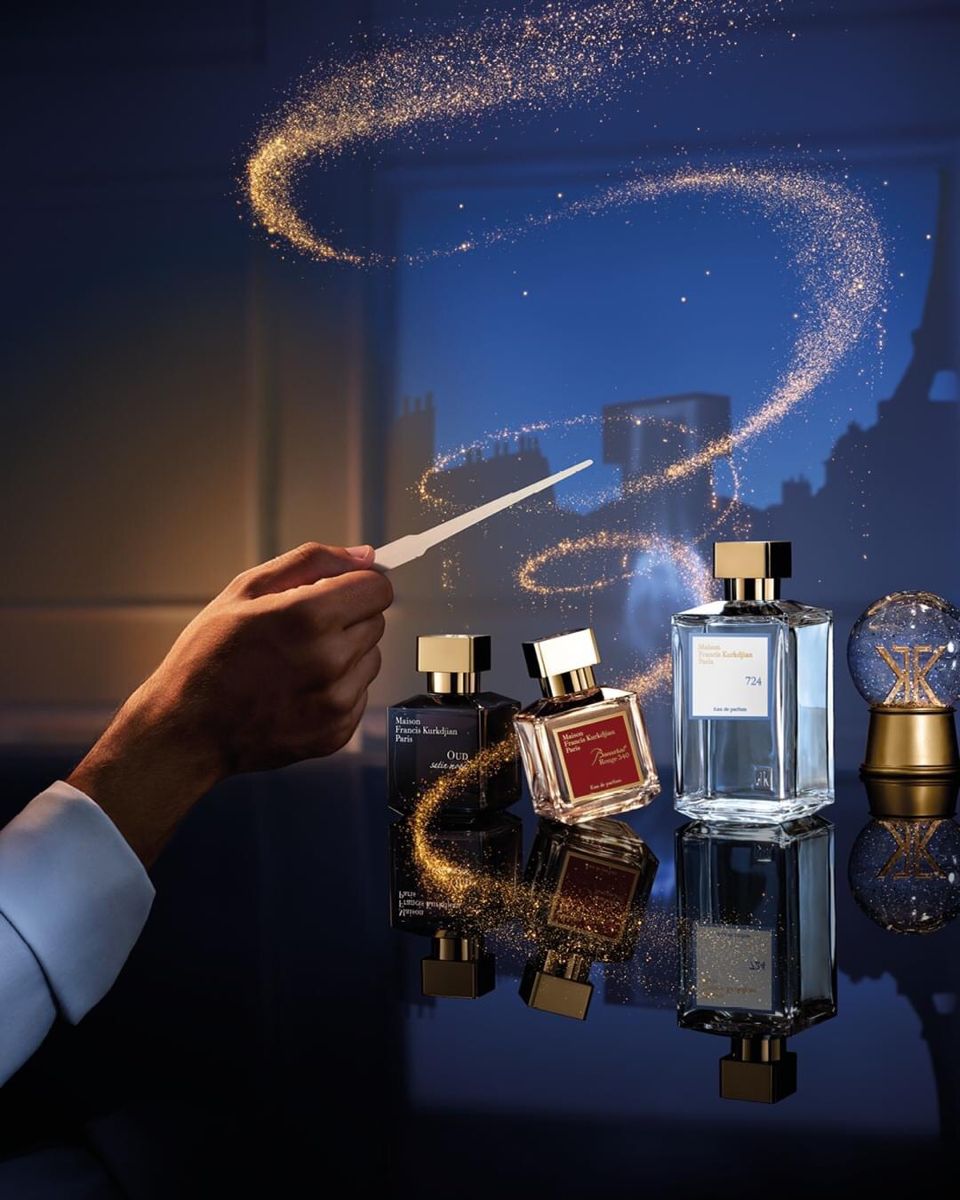 Christmas Instagram post: Hand waving a scent strip like a wand, casting gold sparkles over perfume bottles