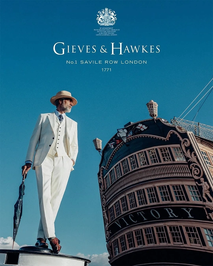 Fashion creative ad: A sharply dressed man in a white suit standing beside an ornate London building