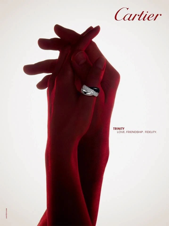 Valentine's Day creative ad: Two red-toned intertwined hands wearing a diamond and black ceramic ring